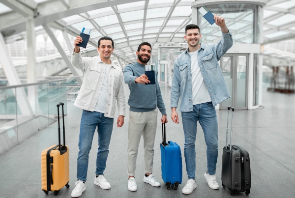 Viajes de incentivo características; Empleados de empresa en el areopuerto sosteniendo sus pases de viaje de incentivo por parte de su empresa.